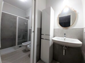 Een douche, een haardroger, een bidet, handdoeken