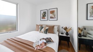 Ein Schlafzimmer mit einem Bett, Nachttischen und Bildern an den Wänden.