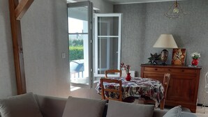 Una sala de estar moderna con un sofá, una mesa de comedor y una araña.