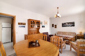 Un coin repas comprenant une table et des chaises en bois, un buffet et un canapé.