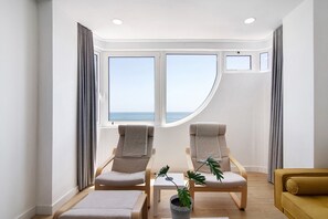 A room with two chairs, a small table, a potted plant, and a sofa. - Holiday Apartment 'Moderno E Renovado T2' with Sea View, Balcony & Wi-Fi (Quarteira)