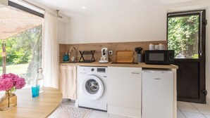 A compact kitchen with a washing machine, a microwave, and a small refrigerator. - Holiday Gîte 'T1 Ardeche Vesseaux' with Mountain View, Shared Garden & Wi-Fi (Vesseaux)