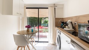A compact kitchen with a coffee maker, a microwave, and a washing machine. - Holiday Gîte 'T1 Ardeche Vesseaux' with Mountain View, Shared Garden & Wi-Fi (Vesseaux)