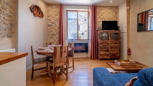 Un salon chaleureux avec une cheminée, des meubles en bois et un mur en pierre.