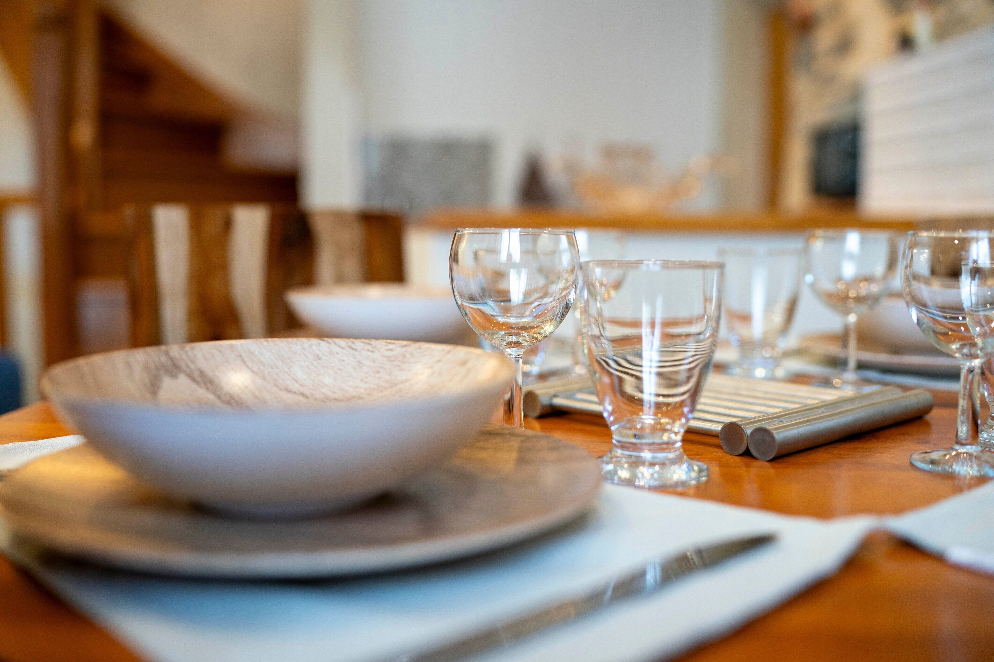 Een eettafel met een kom, borden en bestek.