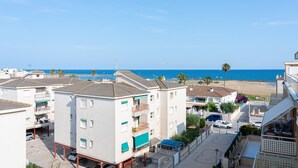 Un quartier résidentiel situé sur la côte, avec des immeubles à plusieurs étages, un parking et une vue sur la mer.