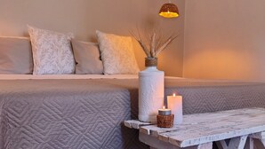 A cozy room with a wooden bench, a white textured sofa, a hanging pendant light, and a candle on a rustic table. - Villa 'Meridiana Case Al Mare' with Sea View, Private Terrace and Air Conditioning (Mattinata)