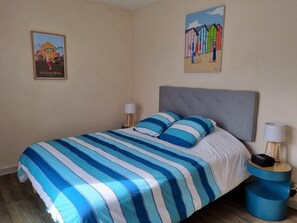 Cozy retreat with a neatly made bed, bedside tables, and a wall-mounted artwork.