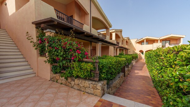 A hotel with a covered outdoor area, stone steps, and a pathway leading to the building. - Apartment 'Casa Vacanze Fragola' with Shared Pool, Private Terrace and Air Conditioning (olbia)