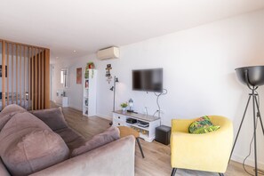 A modern living room with a sofa, a yellow armchair, a TV, and a floor lamp. - Apartment 'Top First Line  Altea' with Sea View, Wi-Fi and Air Conditioning (Altea)
