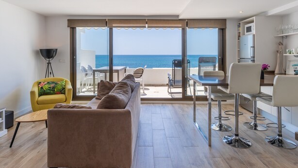 A modern living room with a sofa, yellow armchair, and dining area with bar stools. - Apartment 'Top First Line  Altea' with Sea View, Wi-Fi and Air Conditioning (Altea)