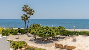 A beach view with palm trees, a stone wall, and a clear sky. - Apartment 'Top First Line  Altea' with Sea View, Wi-Fi and Air Conditioning (Altea)