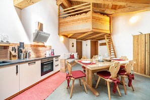 A modern kitchen with wooden cabinets, a built-in oven, and a dining area with a wooden table and chairs. - Holiday Apartment "Larch Soge Apt Paula" with Mountain View, Private Terrace & 2 Balconies (Racines)
