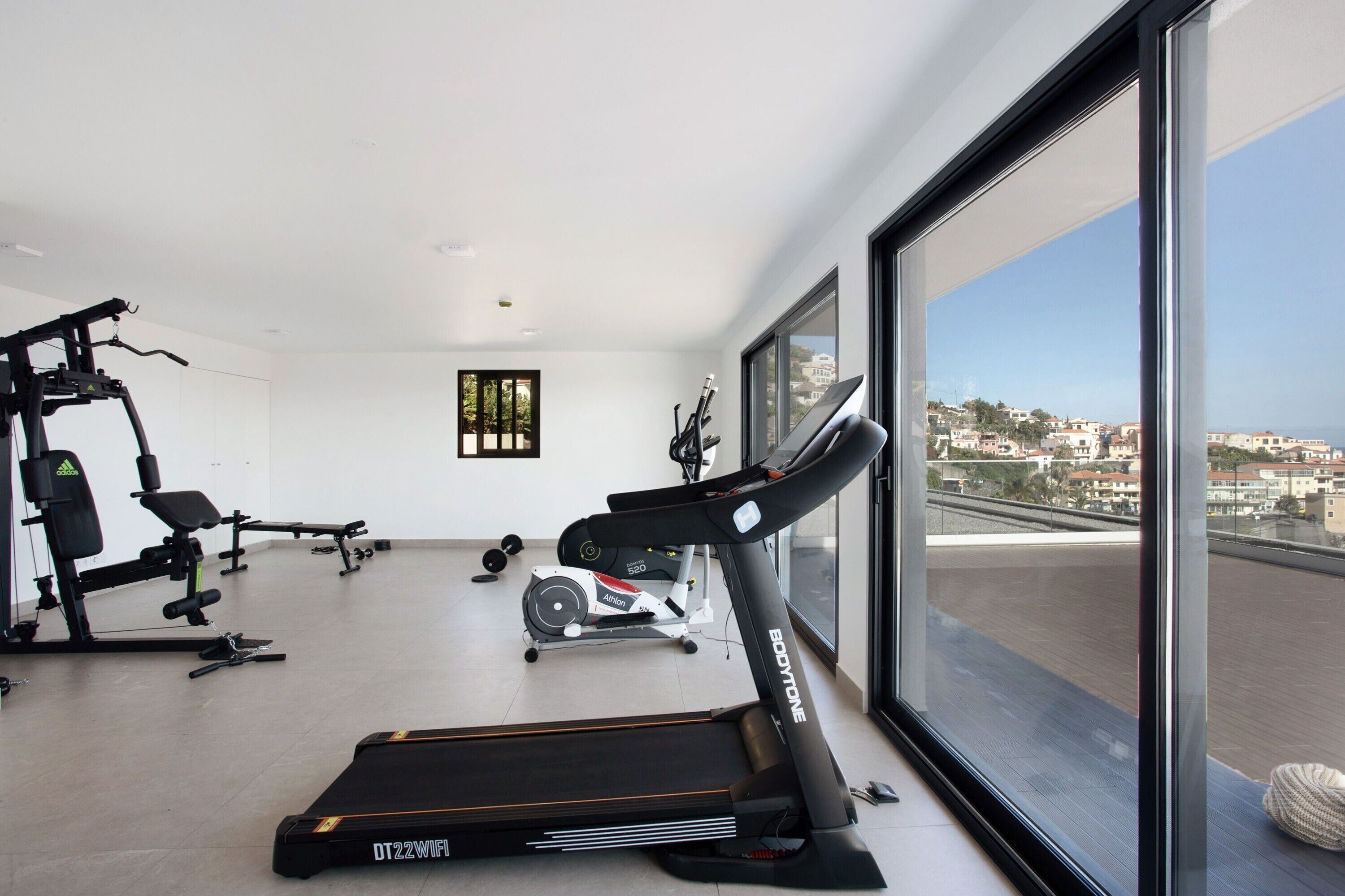 A gym with treadmills, weight machines, and a rowing machine.