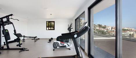 A gym with treadmills, weight machines, and a rowing machine.