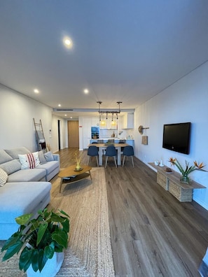 Un salon moderne comprenant un canapé, une table basse et un coin repas avec des chaises et une table.