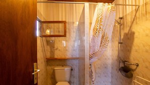 A bathroom with a glass shower enclosure, a toilet, and a wooden door. - Country House with Large Garden, Family Room, and Pet-Friendly in Perigord (Montferrand-du-Périgord)