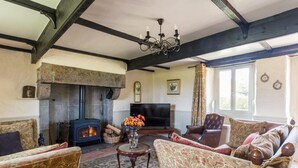 A cozy living room with a fireplace, comfortable seating, and a television.