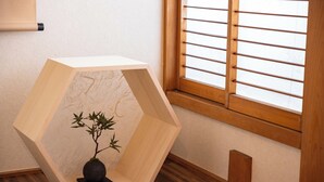 A hexagonal wooden cabinet with a bonsai tree on a dark wooden table. - Precious House Nipponbashi (Osaka)