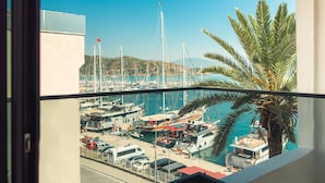 A marina with boats docked, a clear blue sky, and a palm tree. - Dedeoğlu Port Hotel (Fethiye)