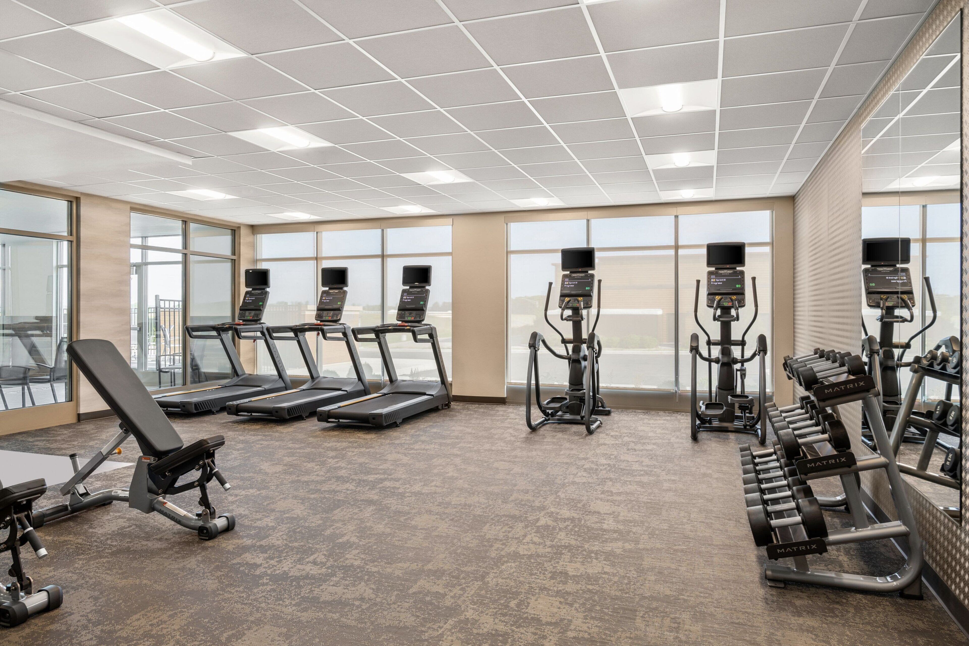 A gym with treadmills, a bench press, and weight machines.