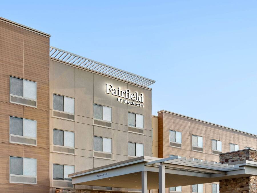 A Fairfield by Marriott hotel with a modern facade, a covered entrance, and a parking lot.