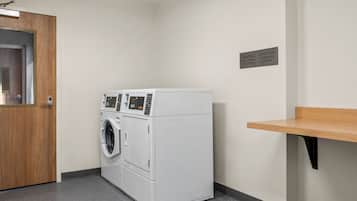 A laundry room with a front desk, a washing machine, and a dryer.