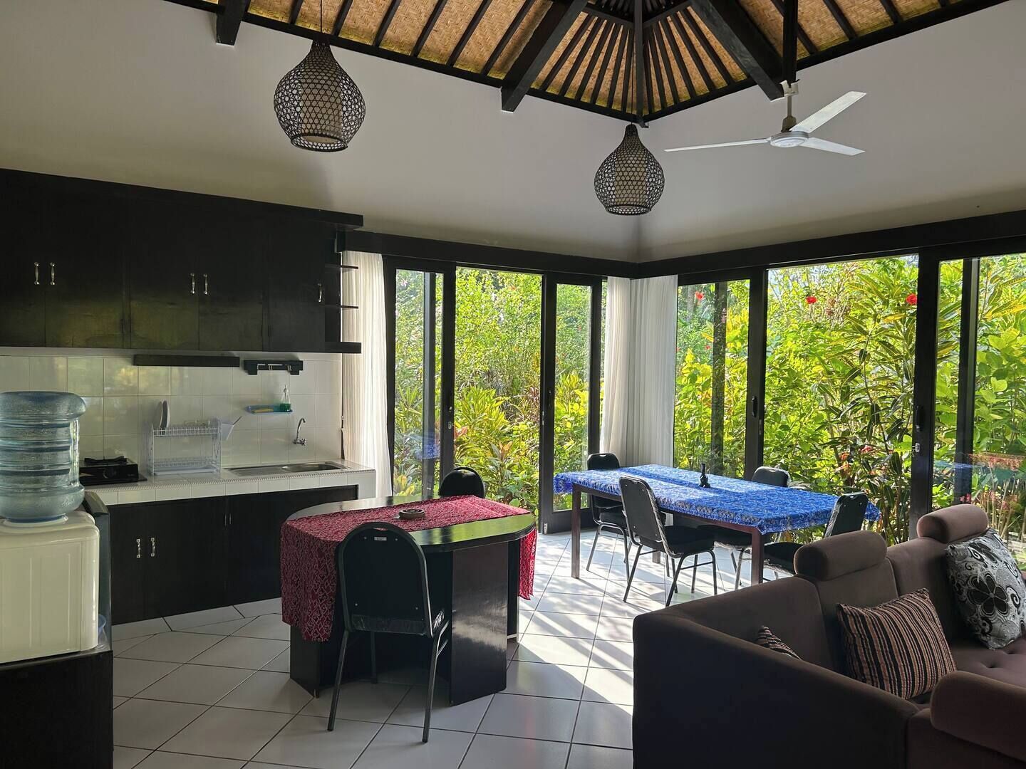 Una cocina moderna con comedor, ventanas amplias y ventilador de techo.