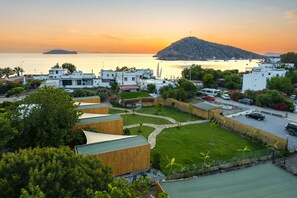 Un pueblo costero con edificios modernos, un puerto deportivo y vistas al atardecer.