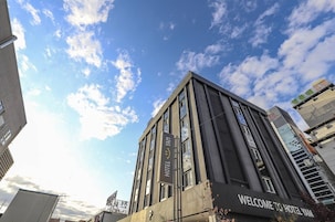 Un moderno edificio de hotel con un letrero que dice "Welcome to Hotel Yam".