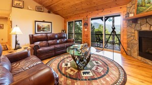 Una sala de estar acogedora con un sofá de cuero, una mesita de centro de cristal y una chimenea.