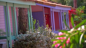 Eine Reihe bunter Holzbungalows mit einem Baum im Vordergrund.
