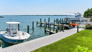 A marina with boats docked, a wooden pier, and a grassy area.