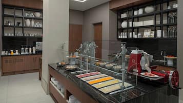 A modern kitchen with a marble countertop, glass display case, and a meat slicer.