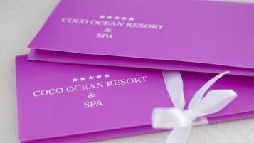 Two purple cards with the text "COCO OCEAN RESORT & SPA" and a white ribbon.