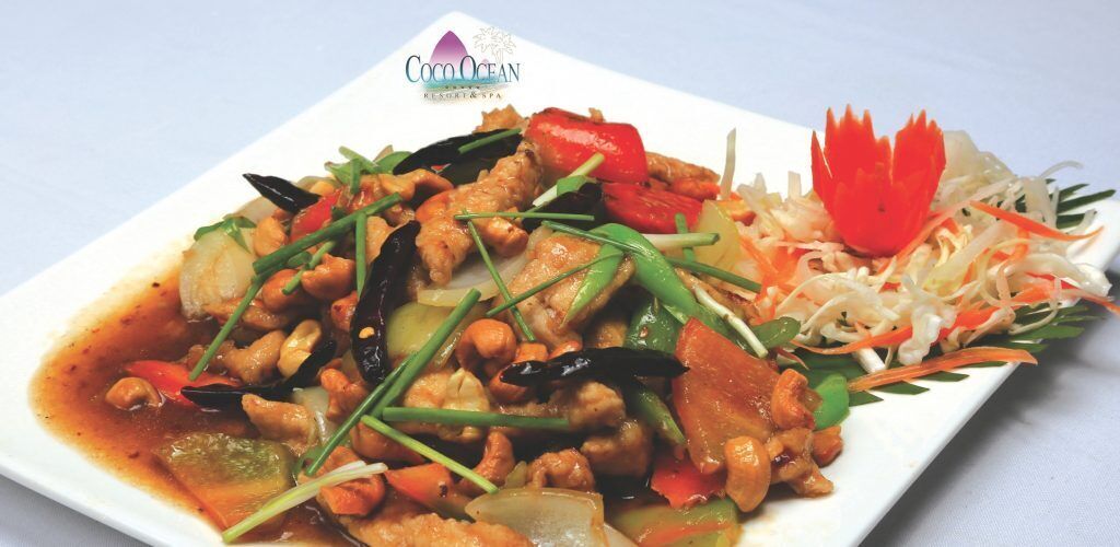 A dish with various vegetables and meat, garnished with a flower-like decoration.