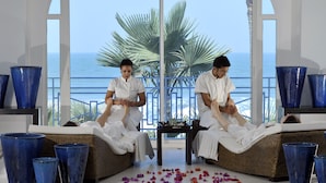 Un área de spa con dos sillones reclinables, grandes jarrones azules y vista al océano.