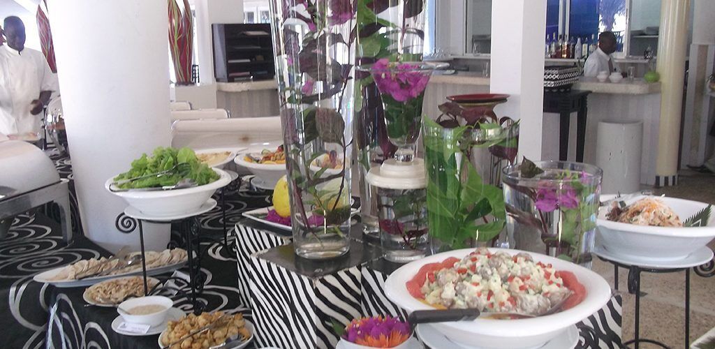 A buffet setup with various dishes and floral centerpieces.