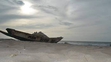 A military aircraft on a sandy beach with the text "MAR" and "REB" visible on its side.