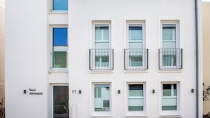 Un edifici modern amb teulada vermella, parets blanques i nombroses finestres.