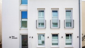 Ein modernes Gebäude mit rotem Dach, weißen Wänden und zahlreichen Fenstern.