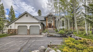 A two-story house with a garage, a front porch, and a stone foundation.