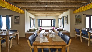 A dining area with a wooden table set for six, surrounded by chairs. -  Pangong Retreat Camp (Leh)