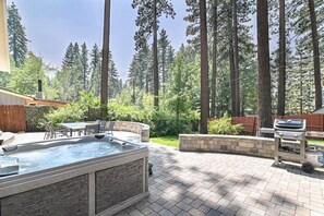 Ein Garten mit Whirlpool, Grill und Gartenmöbeln.