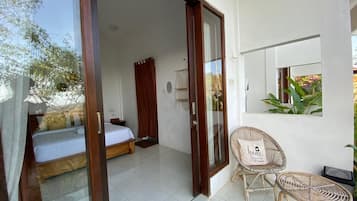 Un dormitorio con una cama, una silla y una mesita.