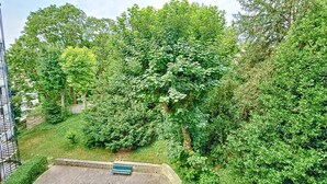 A lush green park with a stone bench and a staircase leading up to a building. - Appartement Centre-ville Proche Paris et Versailles (Sèvres)