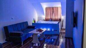 Una sala de estar moderna con un sofá azul, una mesita con un jarrón y un ventanal con cortinas.