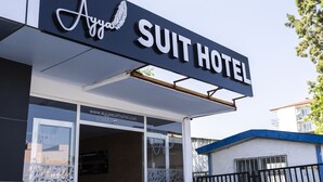 Una entrada de hotel moderna con un cartel que dice "Ayyasuit Hotel" y una escalera que lleva a la entrada.