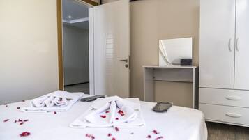 Une chambre d’hôtel comprenant un lit, une armoire, une table de chevet et une porte donnant sur une autre pièce.