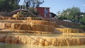 Piscinas en terrazas con un edificio al fondo.